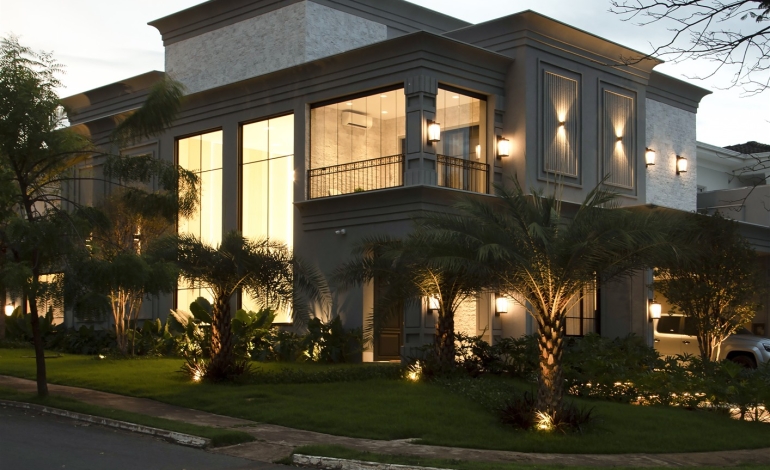 Fachada da residência ao entardecer após o retrofit — Casa Florais Cuiabá
