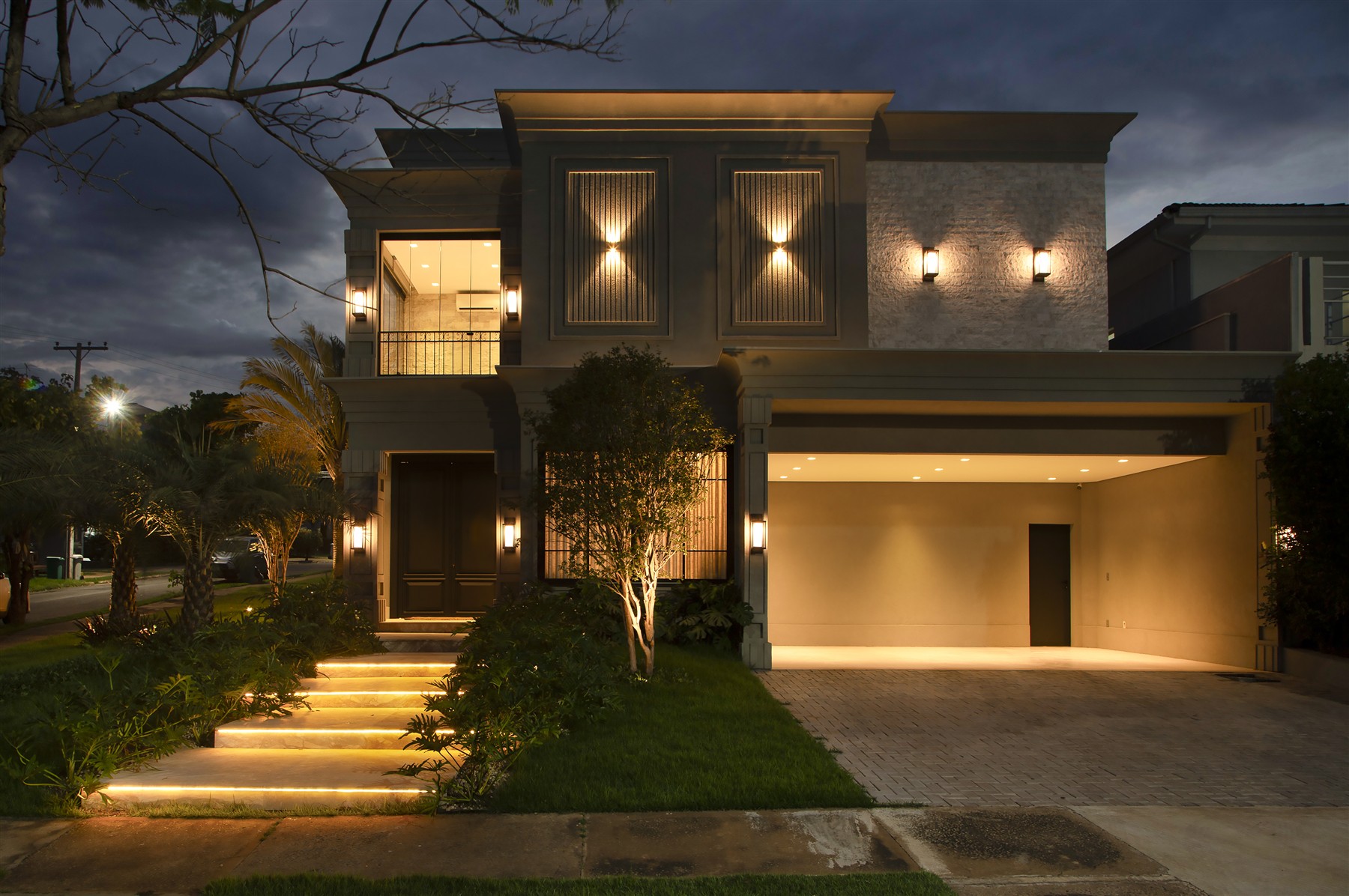 Fachada iluminada à noite — Casa Florais Cuiabá